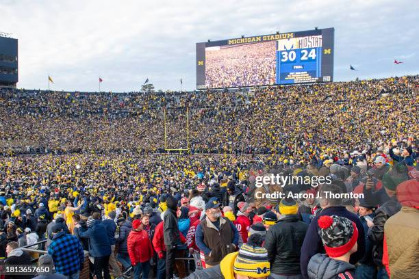 General view of fans celebrating and rushing the field after a college football game between the Michigan Wolverines and Ohio State Buckeyes at...