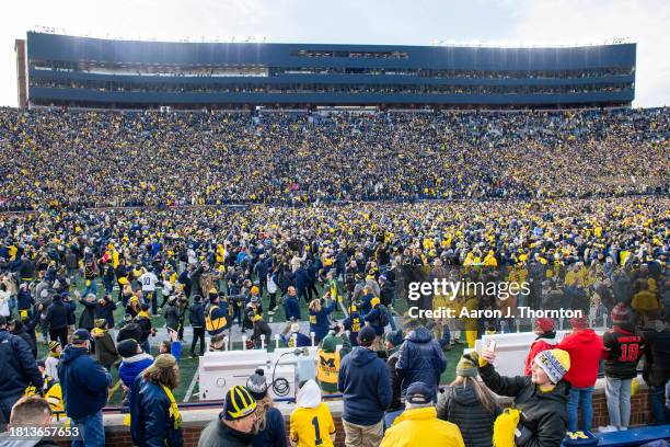 General view of fans celebrating and rushing the field after a college football game between the Michigan Wolverines and Ohio State Buckeyes at...
