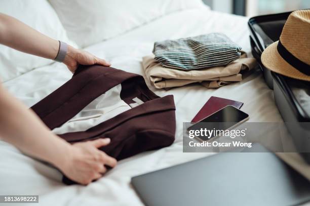 closeup of young woman packing luggage for business and leisure trip - folded hands stock pictures, royalty-free photos & images
