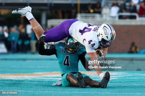 Zach Horton of the James Madison Dukes trips over Tobias Fletcher of the Coastal Carolina Chanticleers during the first half at Brooks Stadium on...