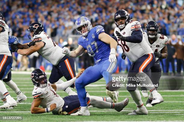 Aidan Hutchinson od the Detroit Lions and Darnell Wright of the Chicago Bears go after a fumble by Justin Fields in the fourth quarter of a game at...