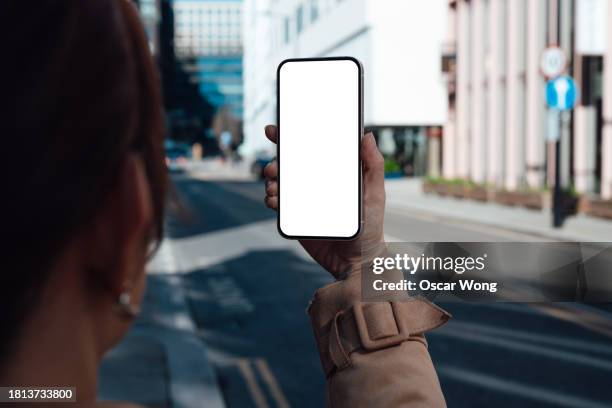 young woman using smartphone on city street - augmented reality phone stock-fotos und bilder