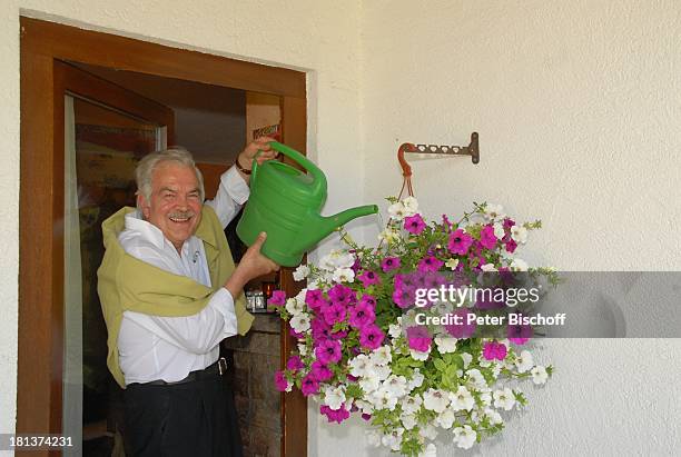 Claus Wilcke, Homestory, Rot am See, Landkreis Schwäbisch Hall, Baden-Württemberg, Deutschland, Europa, Ampel-Pflanze gießen, vor Haustür, Gießkanne,...