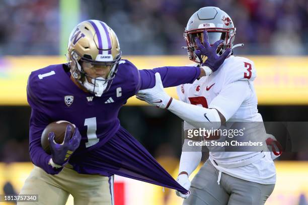 Cam Lampkin of the Washington State Cougars tackles Rome Odunze of the Washington Huskies during the first quarter at Husky Stadium on November 25,...