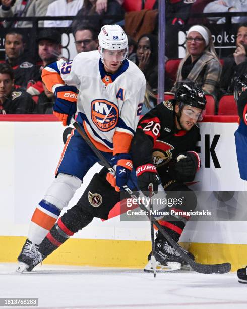 Brock Nelson of the New York Islanders and Erik Brannstrom of the Ottawa Senators battle along the boards during the third period at Canadian Tire...