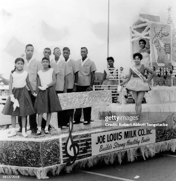 Representatives of the Joe Louis Milk Company ride atop their float, during the annual Bud Billiken Day parade, Chicago, Illinois, 1958.