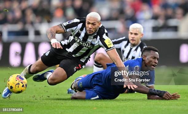 Chelsea player Nicolas Jackson is challenged by Newcastle player Joelinton during the Premier League match between Newcastle United and Chelsea FC at...