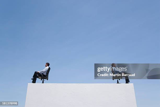 two businessmen on wall with office chairs - conflict stock pictures, royalty-free photos & images