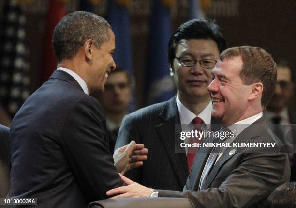 President Barack Obama speaks with Russia's President Dmitry Medvedev at the start of the first plenary session of the 2012 Nuclear Security Summit...