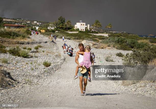 Tourists are evacuated as huge wildfire rages across Greece's Rhodes island on July 22, 2023. Thousands of tourists were evacuated from hotels on the...