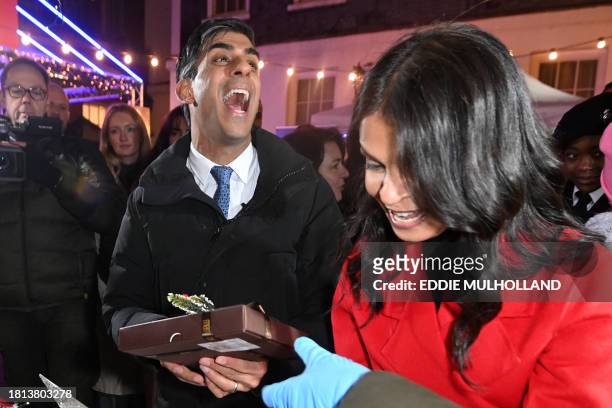 Britain's Prime Minister Rishi Sunak, and his wife Akshata Murty visit the market set up in Downing Street ahead of a ceremony to switch on the...