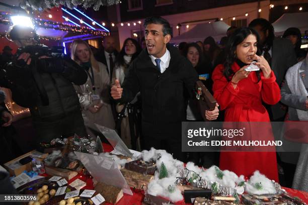 Britain's Prime Minister Rishi Sunak, and his wife Akshata Murty visit the market set up in Downing Street ahead of a ceremony to switch on the...