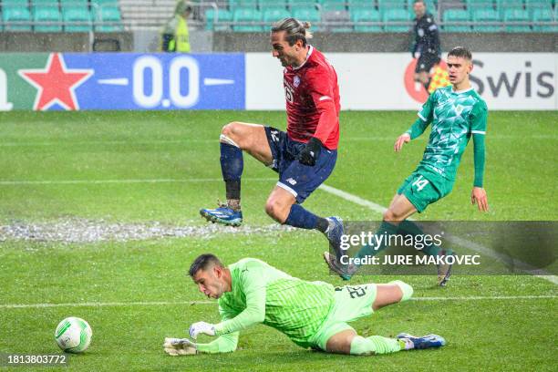 Lille's Turkish forward Yusuf Yazici jumps over Olimpija's Slovenian goalkeeper Denis Pintol during the UEFA Europa Conference League Group A...