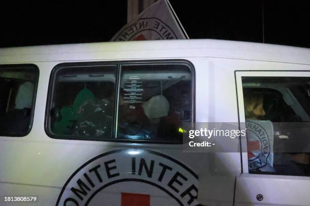 Red Cross convoy transporting released Israeli hostages arrives at Rafah crossing point in the southern Gaza Strip on November 30 amid the release of...
