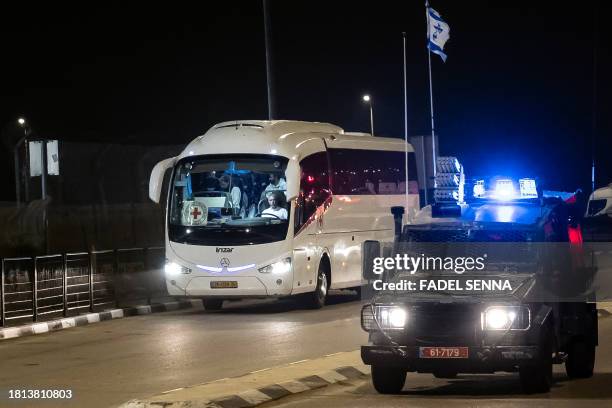 An Israeli border guard vehicle escorts a Red Cross bus the Ofer military prison located between Ramallah and Beitunia in the occupied West Bank on...