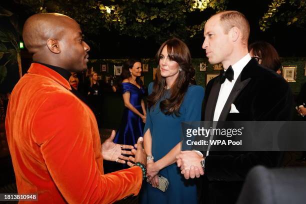 Catherine, Princess of Wales and Prince William, Prince of Wales speak with a performer during the Royal Variety Performance at the Royal Albert Hall...