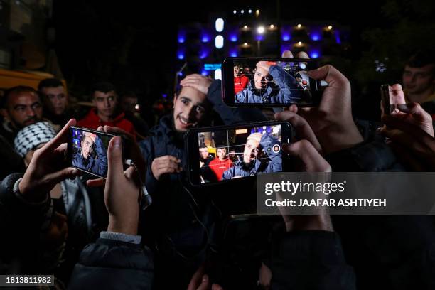 Newly released prisoner gestures amid supporters holding phones during a welcome ceremony following the release of Palestinian prisoners from Israeli...