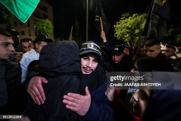 Newly released prisoner hugs a relative during a welcome ceremony following the release of Palestinian prisoners from Israeli jails in exchange for...