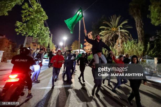 Newly released prisoner waves the Hamas flag during a welcome ceremony following the release of Palestinian prisoners from Israeli jails in exchange...