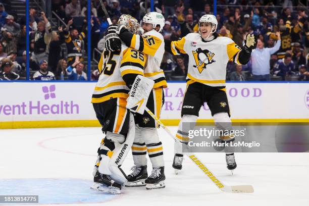 Goalie Tristan Jarry of the Pittsburgh Penguins celebrates his goal with teammate Erik Karlsson against the Tampa Bay Lightning during the third...