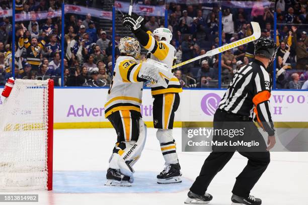 Goalie Tristan Jarry of the Pittsburgh Penguins celebrates his goal with teammate Erik Karlsson against the Tampa Bay Lightning during the third...