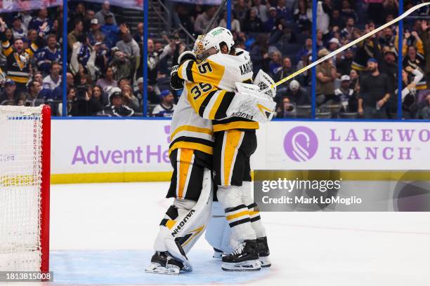 Goalie Tristan Jarry of the Pittsburgh Penguins celebrates his goal with teammate Erik Karlsson against the Tampa Bay Lightning during the third...