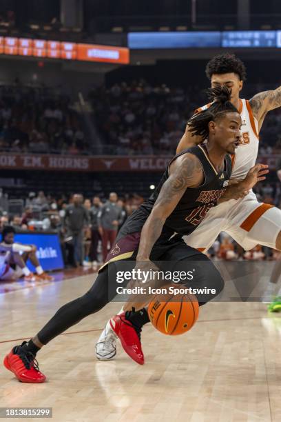 Texas State Bobcats guard Elijah Tate drives towards the basket while being defended by Texas Longhorns guard Chris Johnson during the college...