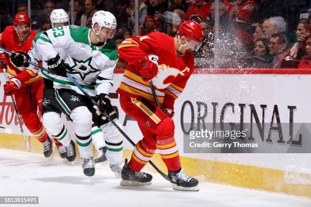 Mikael Backlund of the Calgary Flames battles against Esa Lindell the Dallas Stars at Scotiabank Saddledome on November 30, 2023 in Calgary, Alberta,...