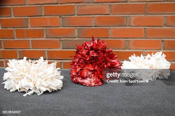 General view of crimson and white pom poms in front of a brick wall during a college basketball game between the American University Eagles and the...