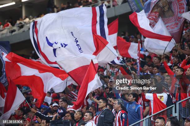 Chivas fans wave flags during the quarterfinals first leg match between Chivas and Pumas UNAM as part of the Torneo Apertura 2023 Liga MX at Akron...