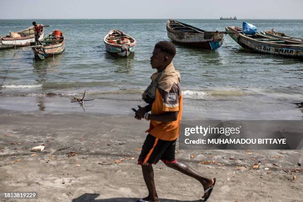 Man walks along the seashore in Banjul on November 30, 2023.