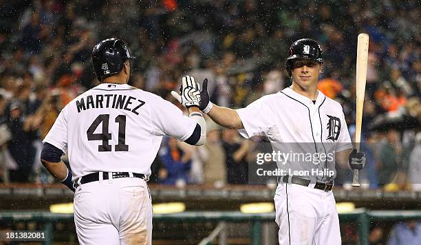 Victor Martinez of the Detroit Tigers celebrates with teammate Andy Dirks after hitting a two-run home run, scoring Prince Fielder in the fifth...