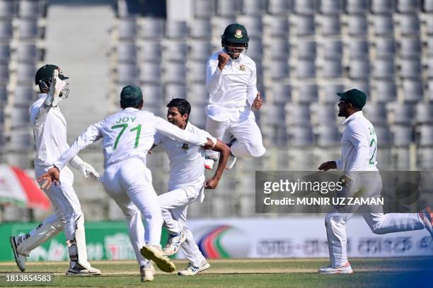 Bangladesh's cricketers celebrate after the dismissal of New Zealand's Kane Williamson during the fourth day of the first Test cricket match between...