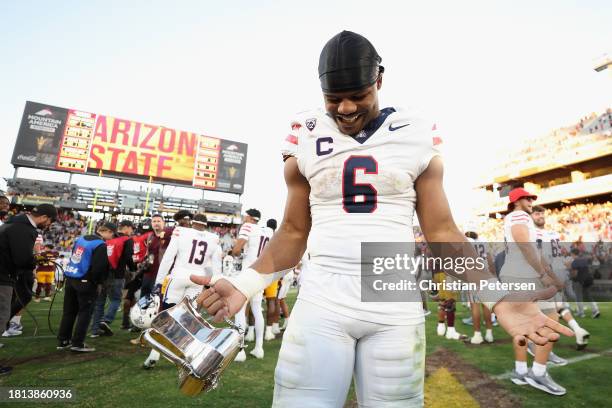Running back Michael Wiley of the Arizona Wildcats celebrates with the Territorial Cup following the NCAAF game at Mountain America Stadium on...