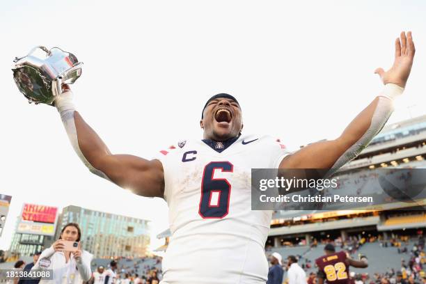 Running back Michael Wiley of the Arizona Wildcats celebrates with the Territorial Cup following the NCAAF game at Mountain America Stadium on...