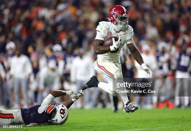 Roydell Williams of the Alabama Crimson Tide rushes for a first down as he leaps away from Keionte Scott of the Auburn Tigers during the fourth...