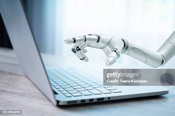 white cyborg hand is touching on a laptop - money robot stock pictures, royalty-free photos & images