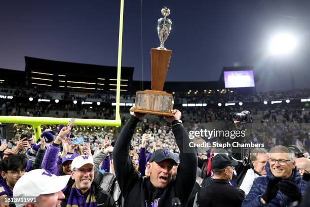 Head coach Kalen DeBoer of the Washington Huskies lifts the 115th Apple Cup after a presentation by Governor Jay Inslee after beating Washington...