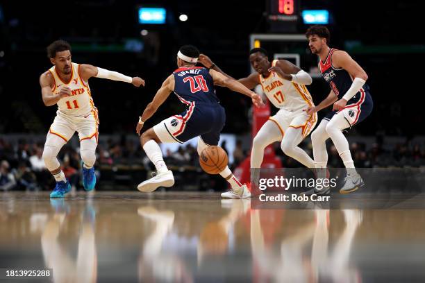 Trae Young, Onyeka Okongwu of the Atlanta Hawks go after a loose ball with Landry Shamet and Deni Avdija of the Washington Wizards during the first...