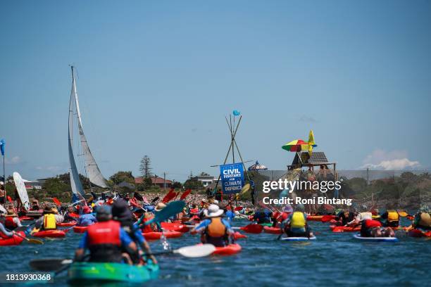 People take to the water as they continue blockade the access to the coal port in protest for climate action at Horseshoe Beach on November 26, 2023...