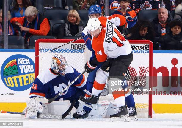 Ilya Sorokin and Noah Dobson of the New York Islanders defend against Sean Couturier of the Philadelphia Flyers during the second period at UBS Arena...