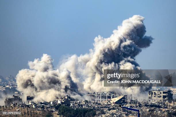 This picture taken from southern Israel near the border with the Gaza Strip shows smoke rising from buildings after being hit by Israeli strikes, as...