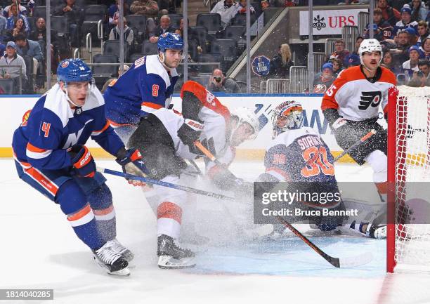 Joel Farabee of the Philadelphia Flyers skate sin on Ilya Sorokin of the New York Islanders during the third period at UBS Arena on November 25, 2023...
