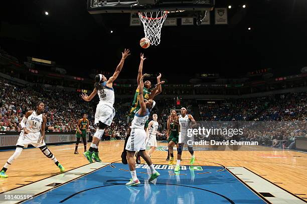 Noelle Quinn of the Seattle Storm goes for the layup against Maya Moore and Monica Wright of the of the Minnesota Lynx during the WNBA Western...