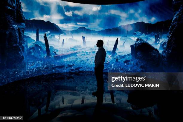 Man looks at a digital display at an exhibition by the Andrey Melnichenko Foundation during the COP28 United Nations climate summit in Dubai on...