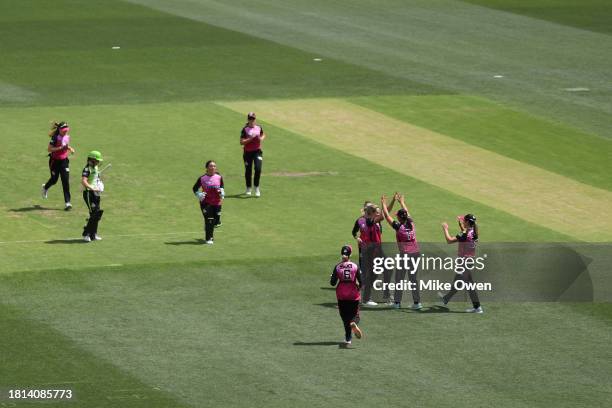 Suzie Bates of the Sixers celebrates with teammates after catching out Phoebe Litchfield of the Thunder during the WBBL match between Sydney Sixers...