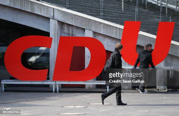 Workers carry away the giant letters of the German Christian Democrats following a CDU election rally the day before federal elections on September...
