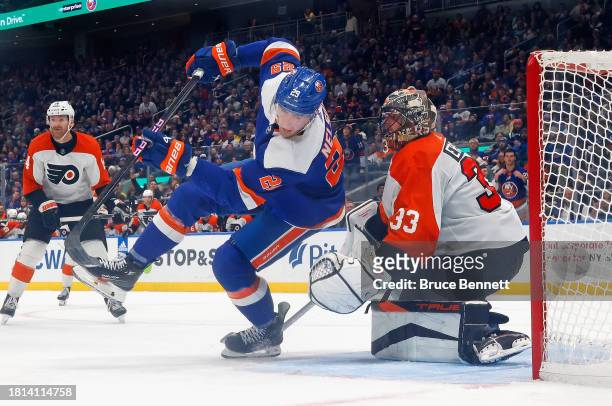 Samuel Ersson of the Philadelphia Flyers defends against Brock Nelson of the New York Islanders at UBS Arena on November 25, 2023 in Elmont, New...