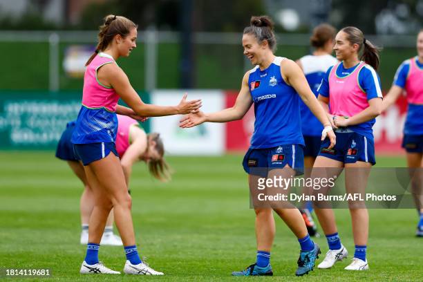 Emma Kearney and Charli Granville of the Kangaroos perform a handshake during the North Melbourne Kangaroos AFLW training session at Arden Street...