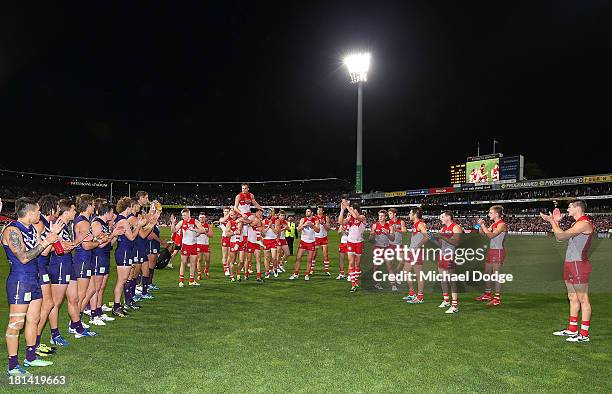 Jude Bolton of the Swans gets carried off by Jarrad Mcveigh and Ryan O'Keefe during the AFL Second Preliminary Final match between the Fremantle...